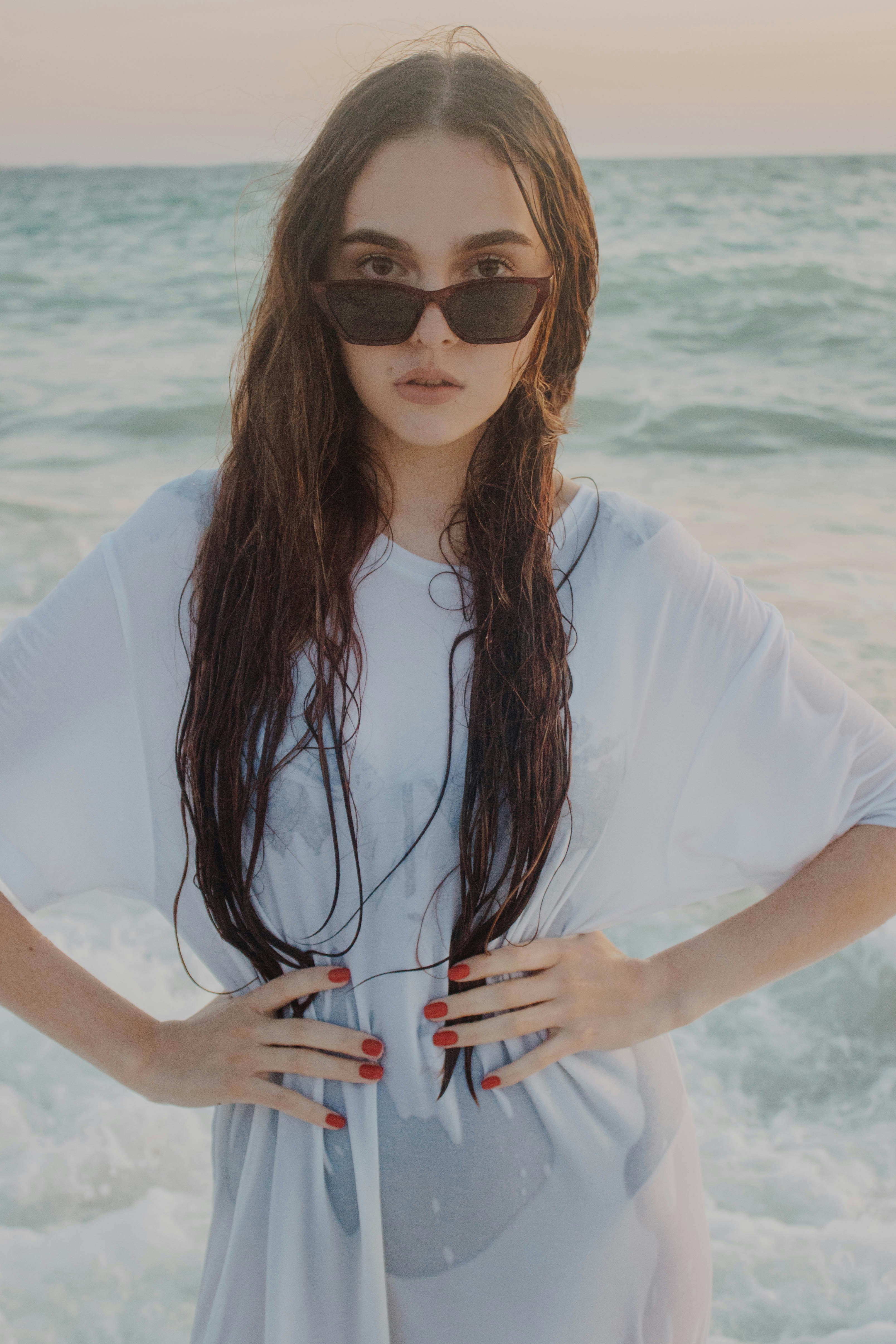 a woman standing on a beach with her hands on her hips