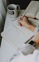 woman writing down on notebook