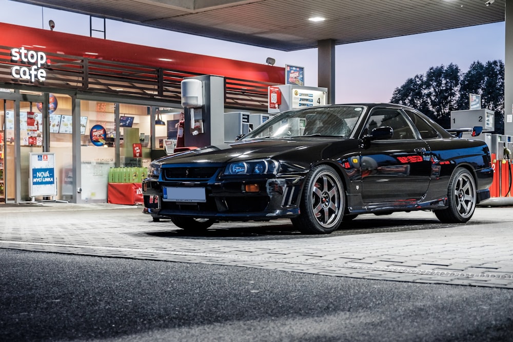 parked black coupe at gas station