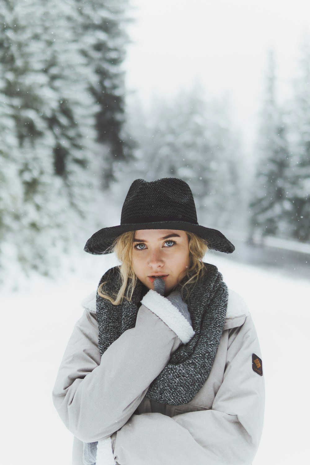 a woman wearing a hat and scarf in the snow