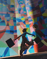 woman holding bag beside mural painting