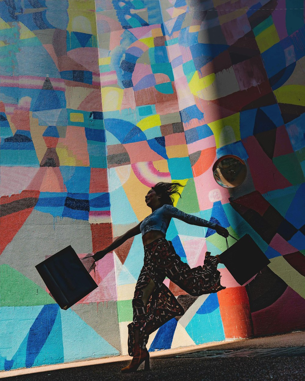 femme tenant un sac à côté de la peinture murale