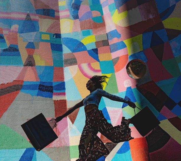 woman holding bag beside mural painting