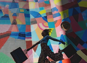 woman holding bag beside mural painting
