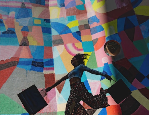 woman holding bag beside mural painting