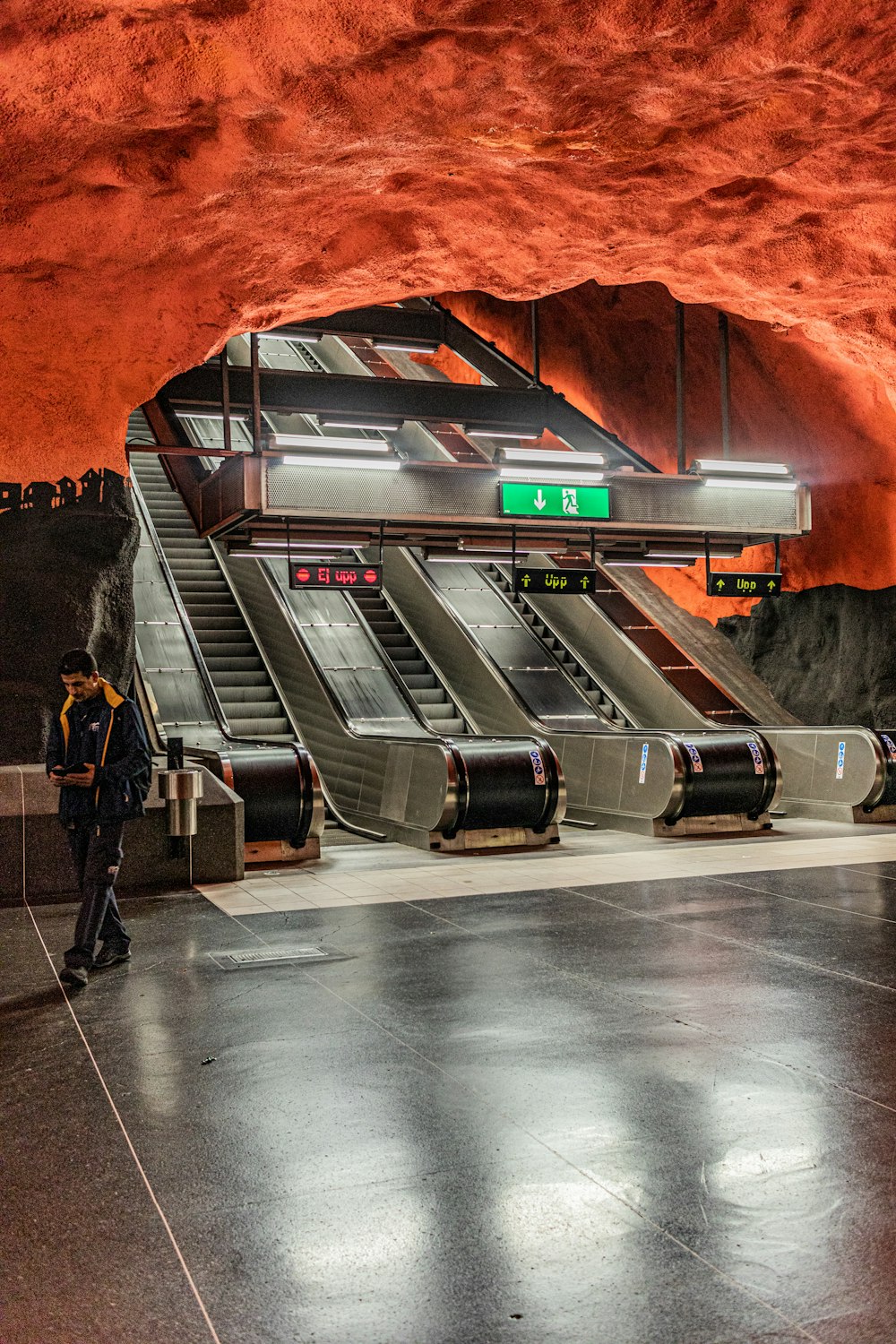 man walking behind escalators