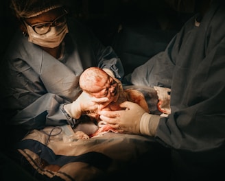 two person holding newborn baby