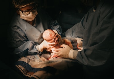 two person holding newborn baby