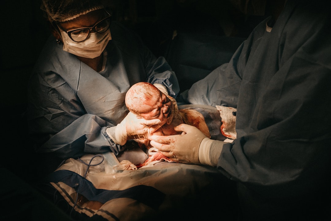 two person holding newborn baby