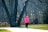 A customer jogging in the park wearing colorful gloves.