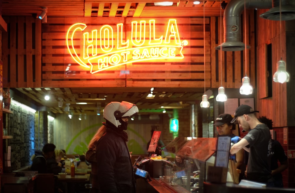 man wearing helmet standing in front of the bar counter