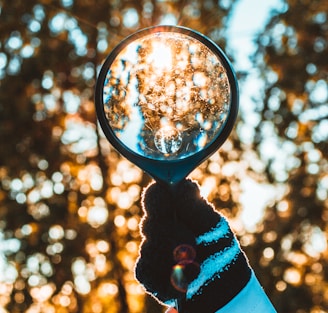 person holding black magnifying glass