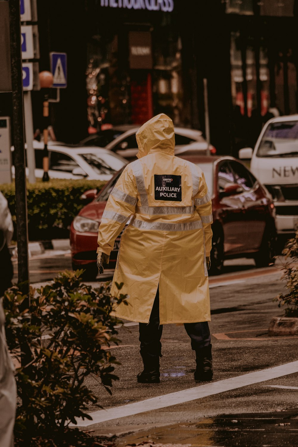 person wearing yellow and gray raincoat walking on street