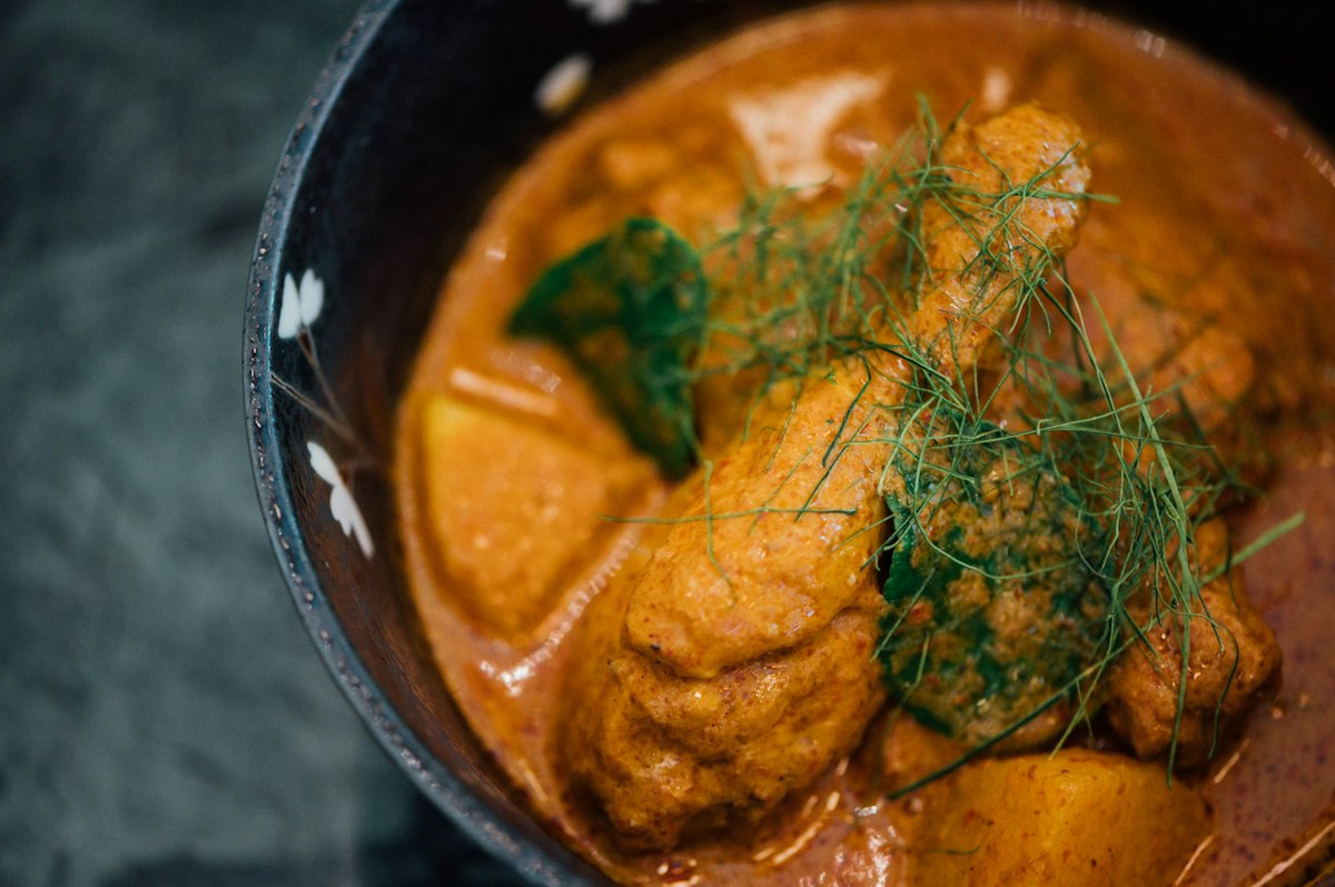 Bengali fish curry machher jhol with light turmeric gravy served with rice