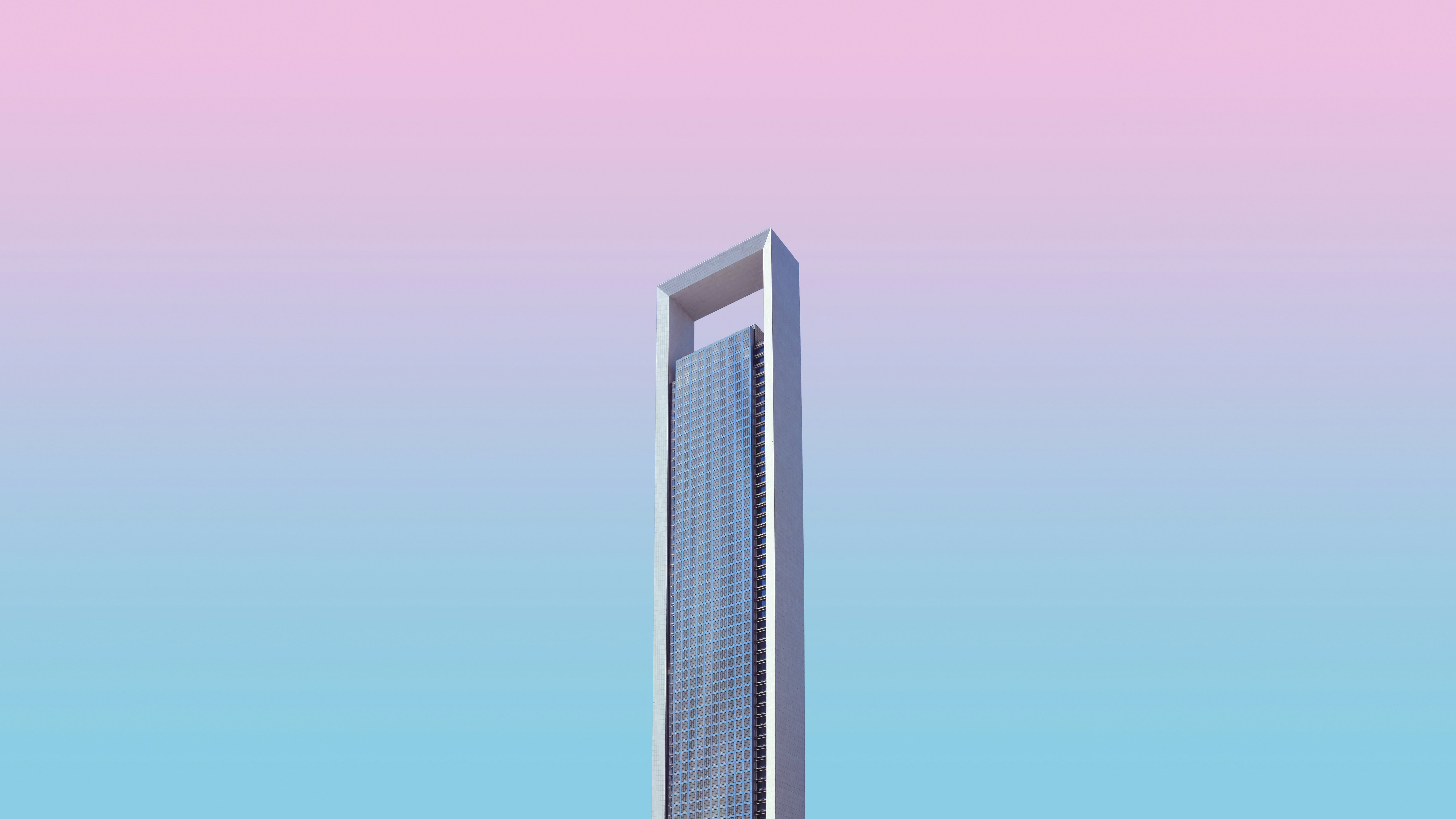 a tall building with a pink sky in the background