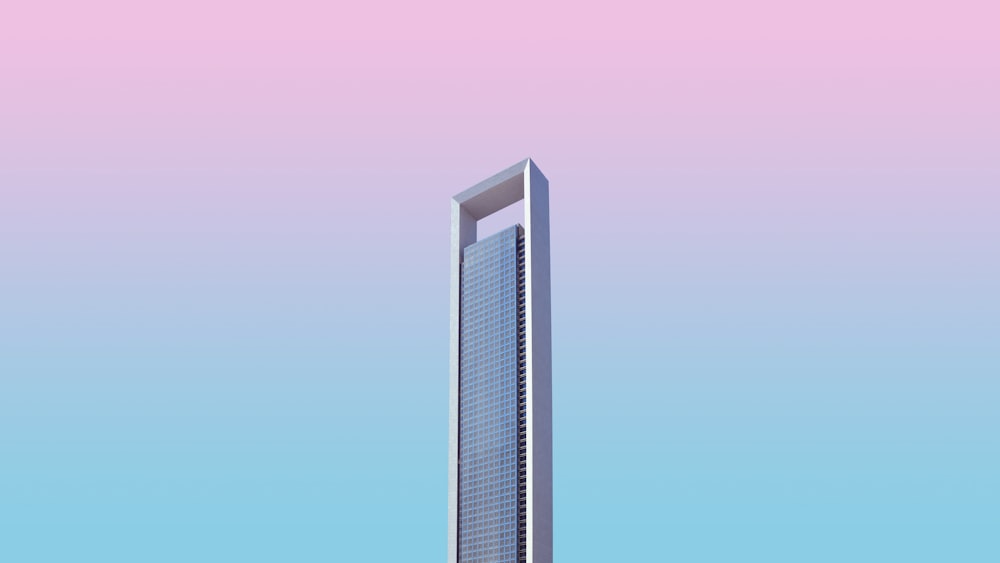 a tall building with a pink sky in the background