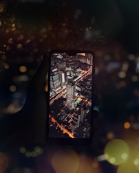 A traveler’s hand holding a compact travel gadget with a blurred cityscape background.