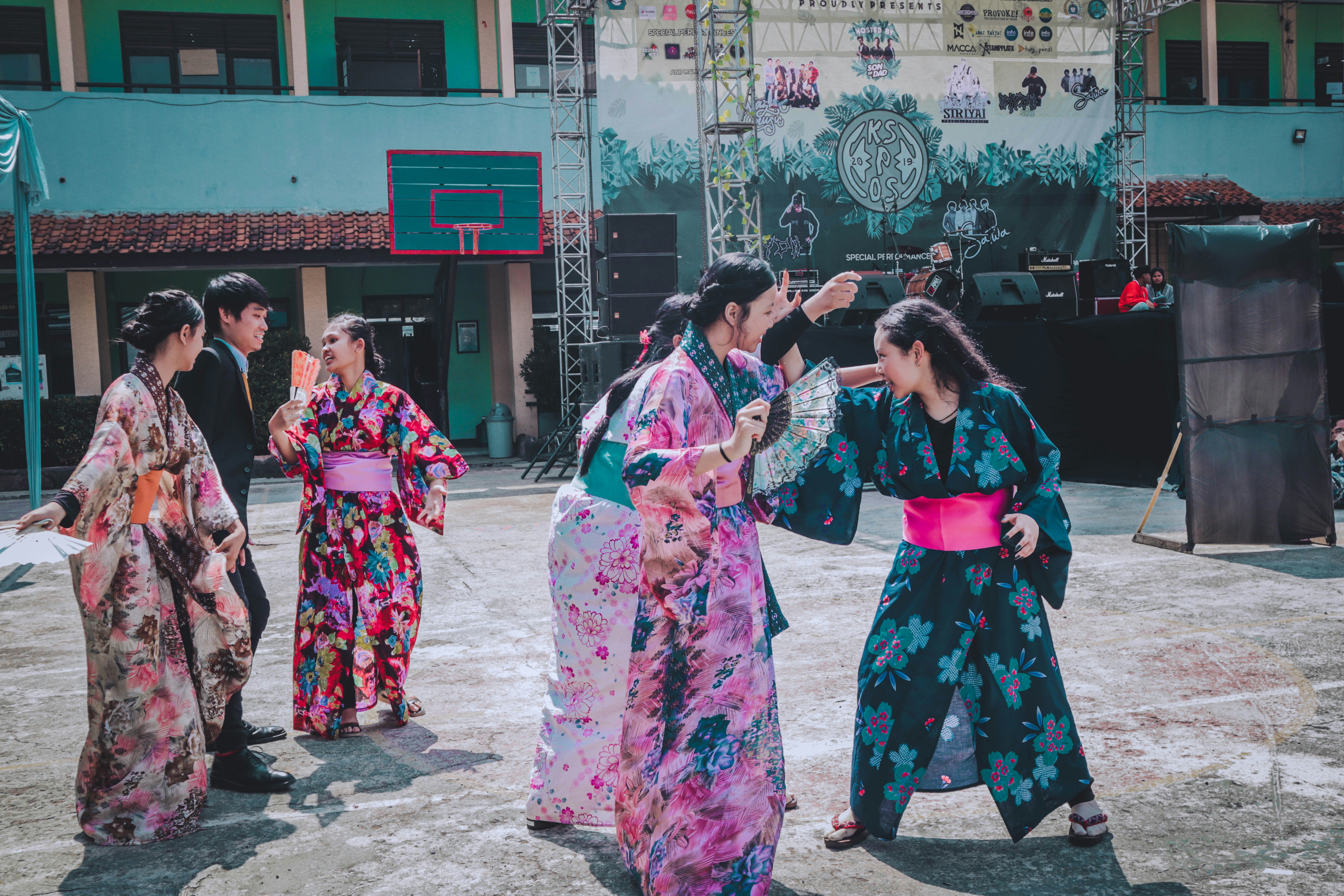 a group of women in kimonos standing in front of a stage