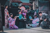 A group of men wearing diverse Japanese clothing styles in a vibrant outdoor setting.