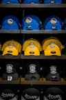 three assorted-color Golden State Warriors caps on shelf