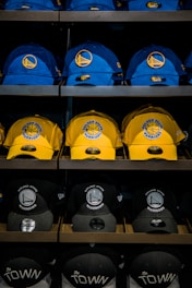 three assorted-color Golden State Warriors caps on shelf