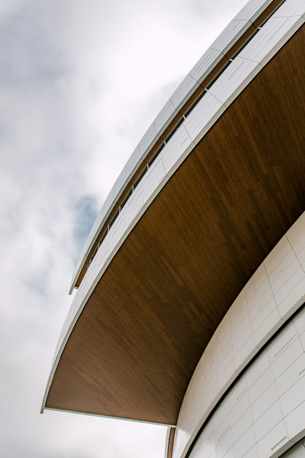 a curved building with a clock on the side of it