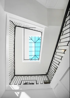 Interior view of a high-end residential stairwell with a large skylight flooding natural light.