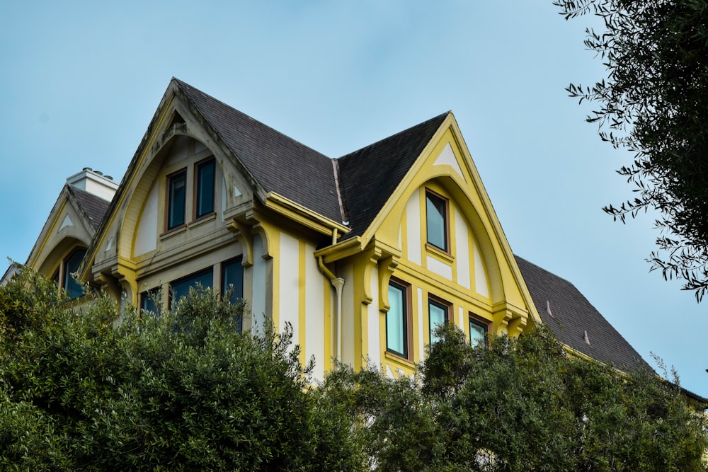 a large yellow house with a black roof