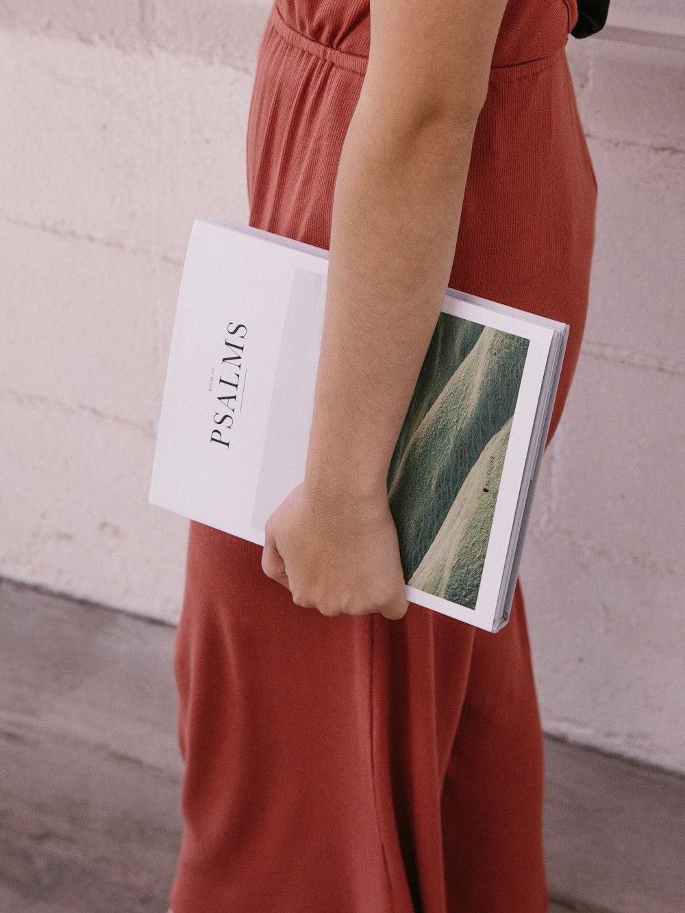 woman wearing red jumpsuit holding Psalms book