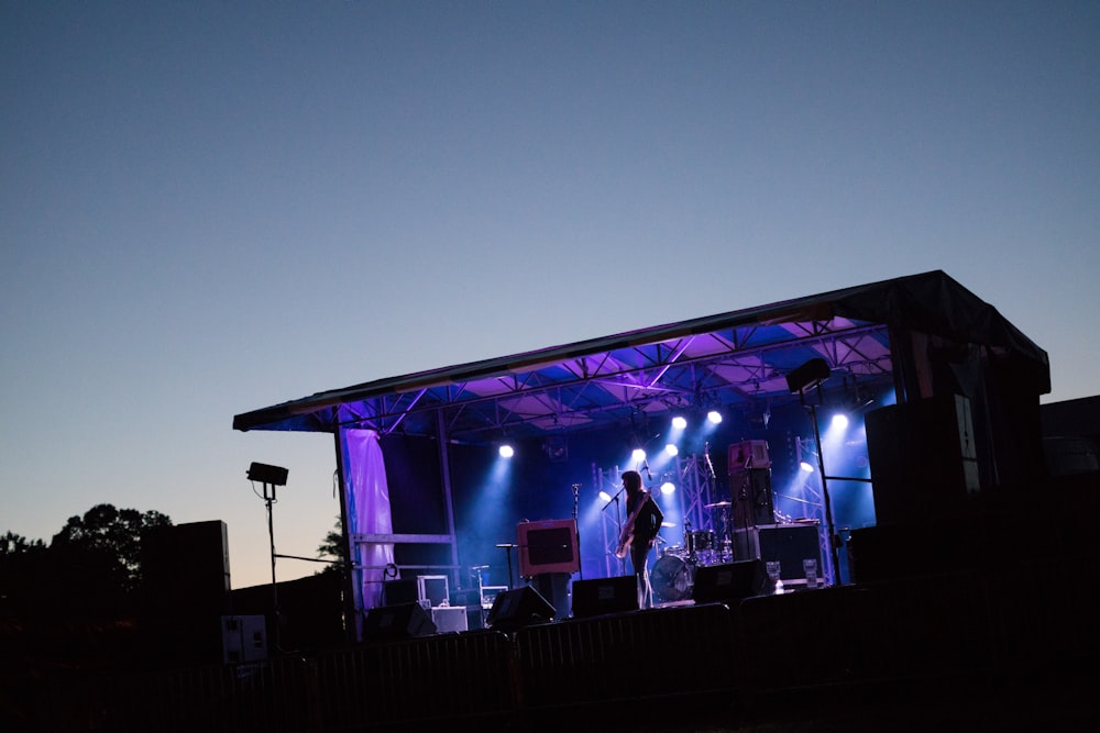 man standing on stage with strobe lights