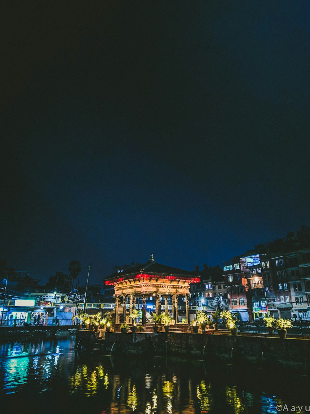 pagoda in front of calm body of water with turned-on lights