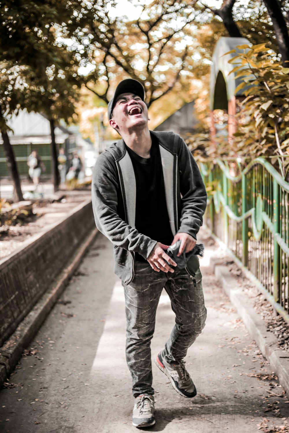 man in gray jacket walking on pathway