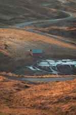 A serene stretch of raw desert land at sunset with a small off-grid cabin nestled among sagebrush.