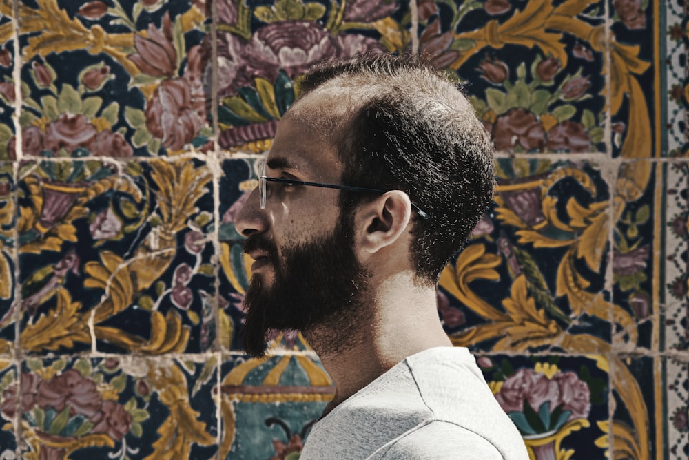 man beside floral wall