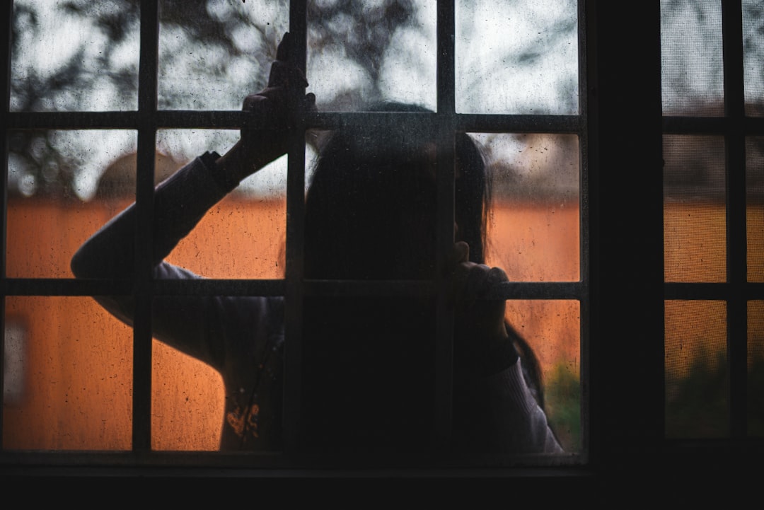 woman leaning on glass window