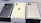Three smartphones are placed in their respective boxes. The phones are different colors: black, gold, and yellow. Each phone features a prominent Apple logo on the back, with the black and gold devices having three camera lenses, while the yellow phone has two.