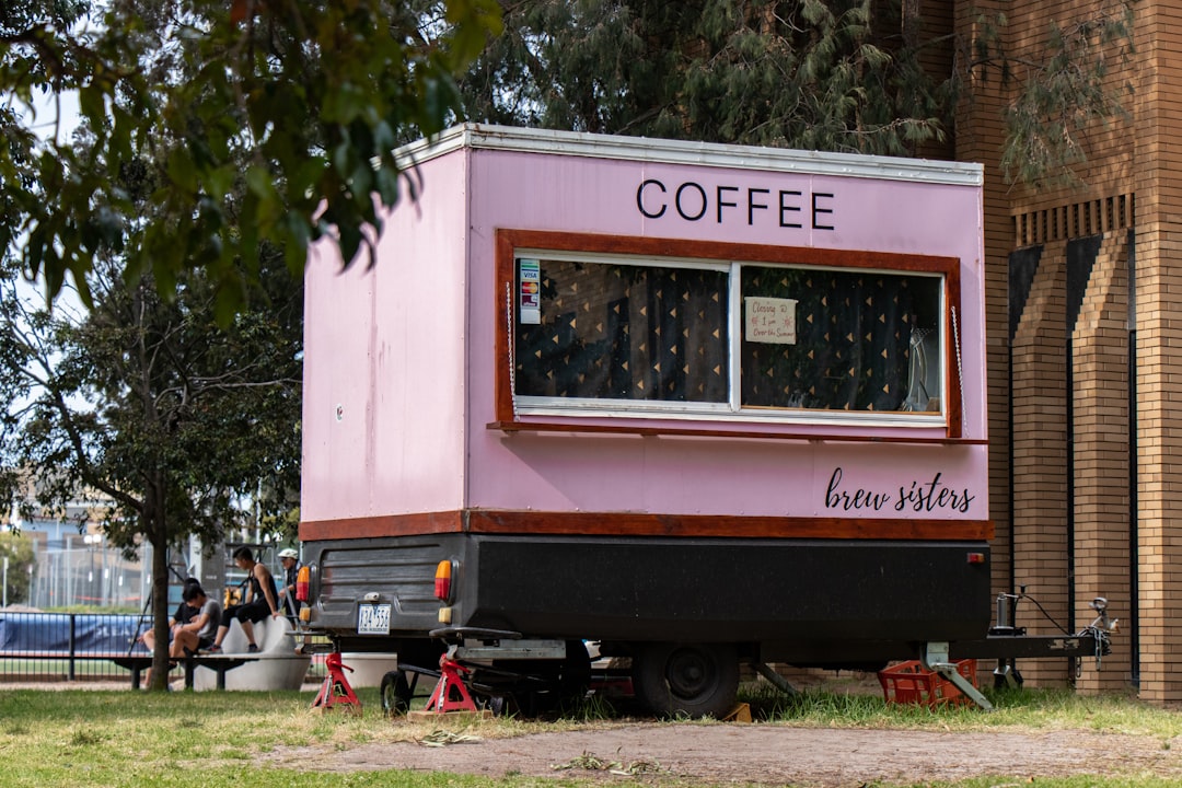 coffee food cart near trees and building during day