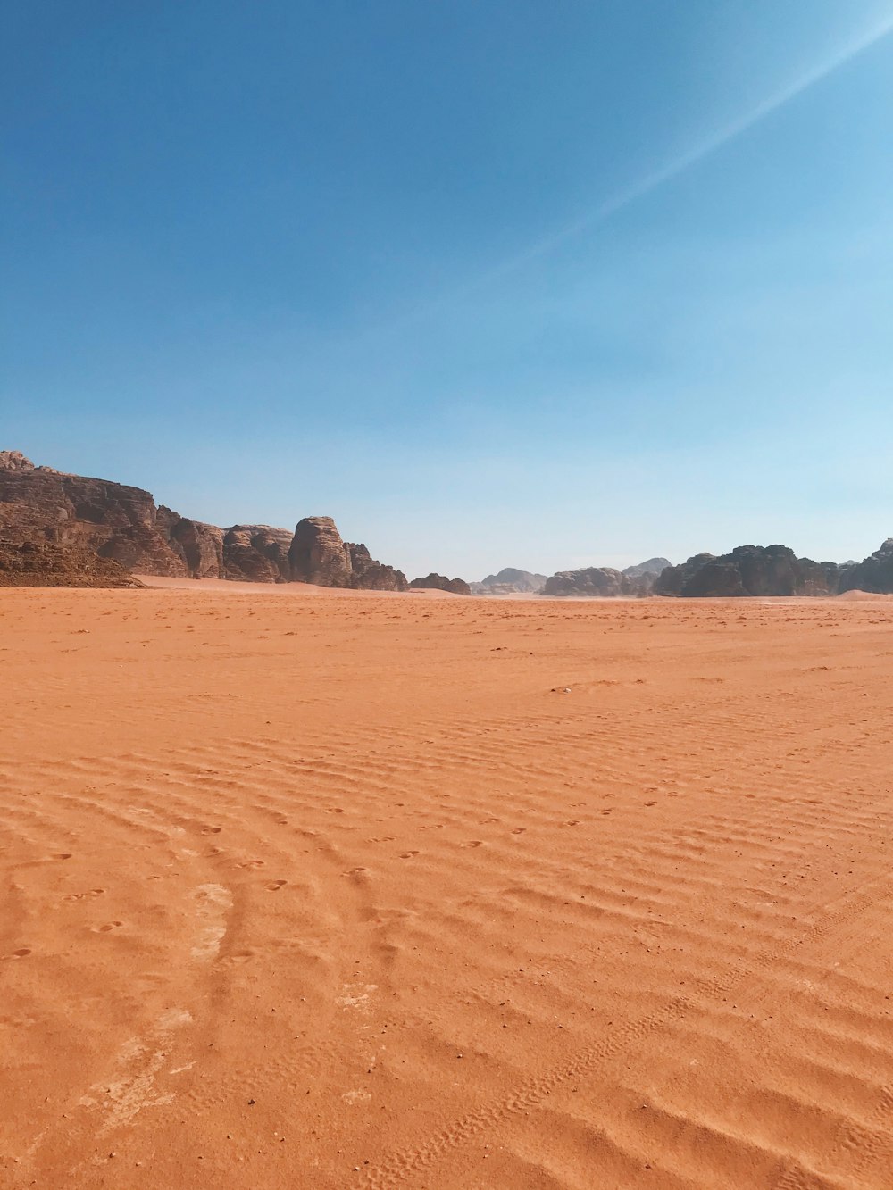 a sandy area with mountains in the background