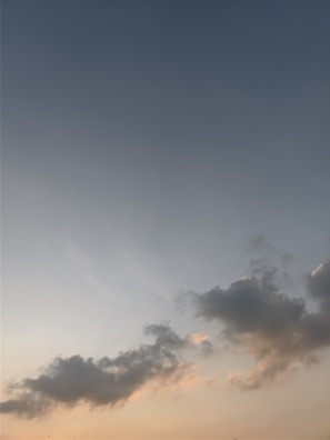 A serene outdoor sky view with soft clouds at sunset.