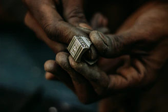 Manos de un artesano tuareg elaborando un anillo de plata tradicional en Djanet, Argelia.