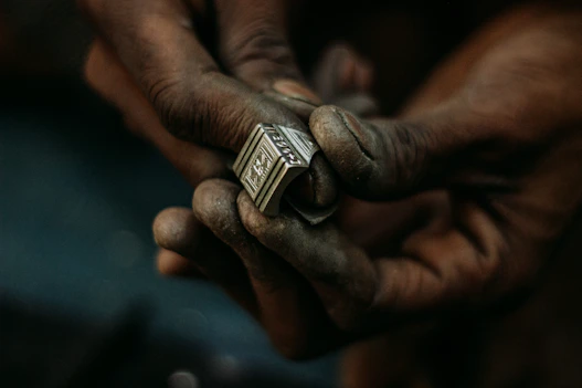 Manos de un artesano tuareg elaborando un anillo de plata tradicional en Djanet, Argelia.