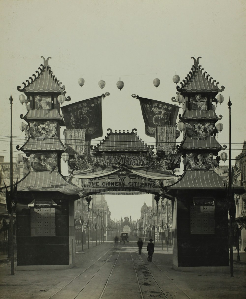 a black and white photo of a person walking under a bridge