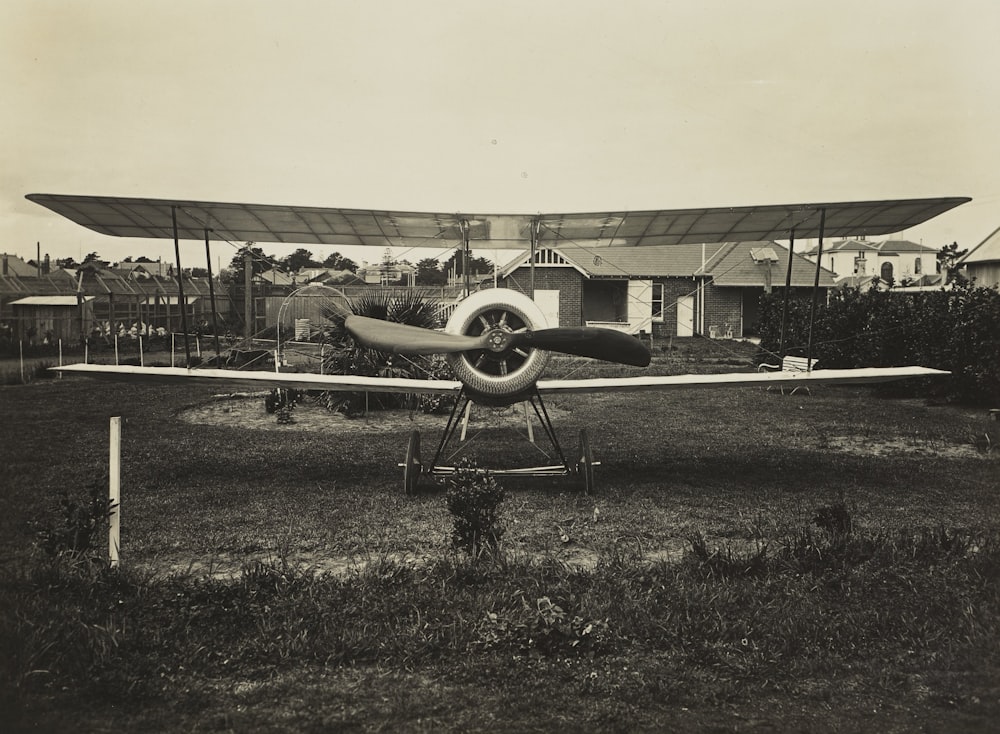 grayscale photography of biplane on field