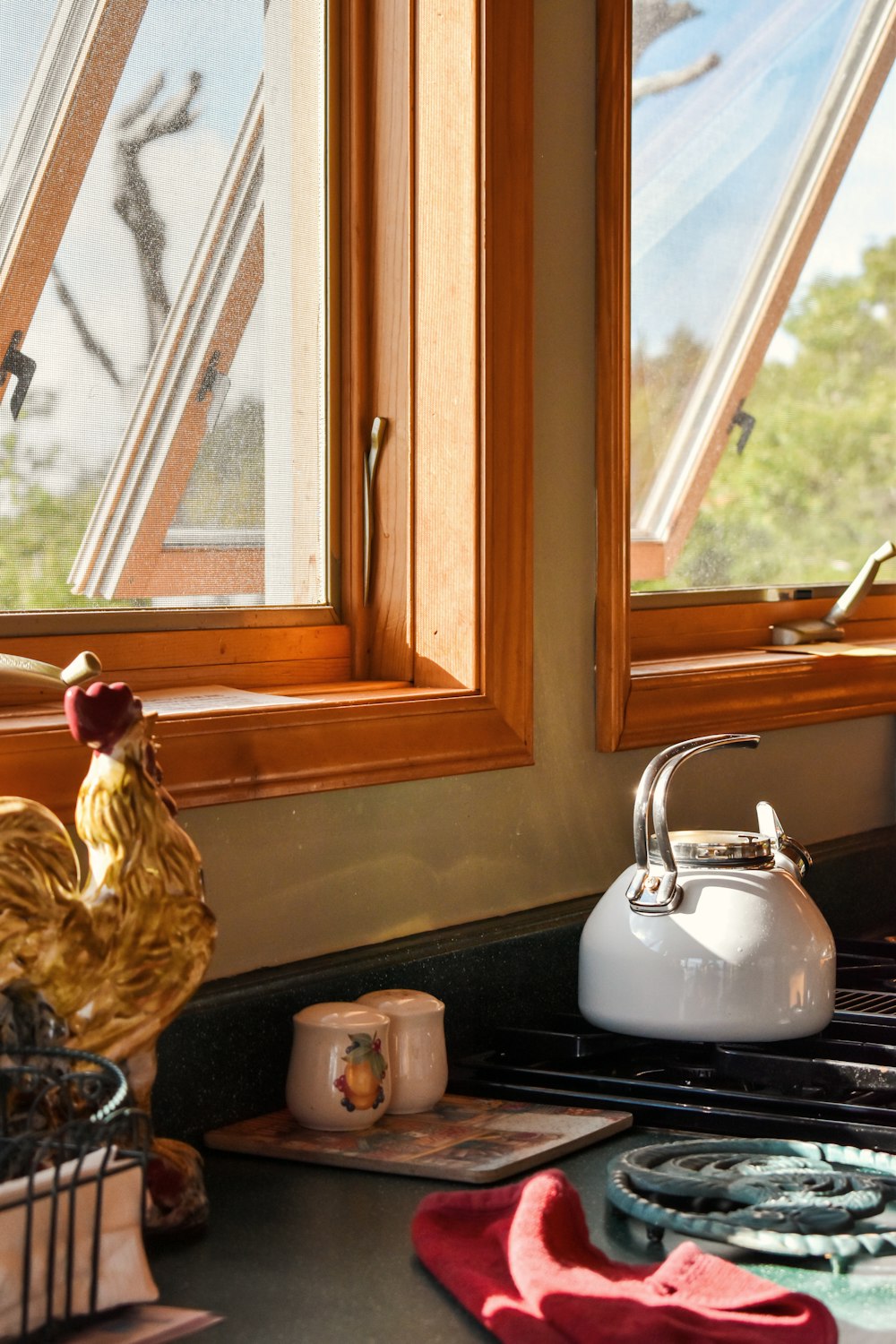 shallow focus photo of white teapot beside window