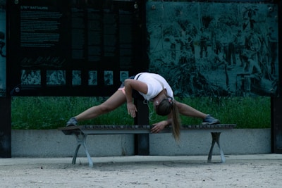 Jody stretching on a park bench before a coaching session at dawn.