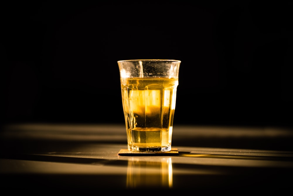 clear drinking glass with yellow liquid