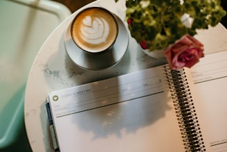 black ceramic coffee cup on saucer filled with cappuccino