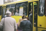 Group of happy passengers boarding a micro-bus with smiling driver ready to depart.