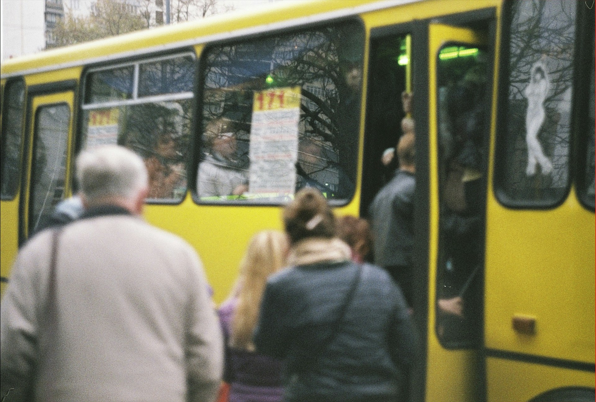 A group of happy travelers boarding a comfortable coach bus ready for a grand tour adventure.