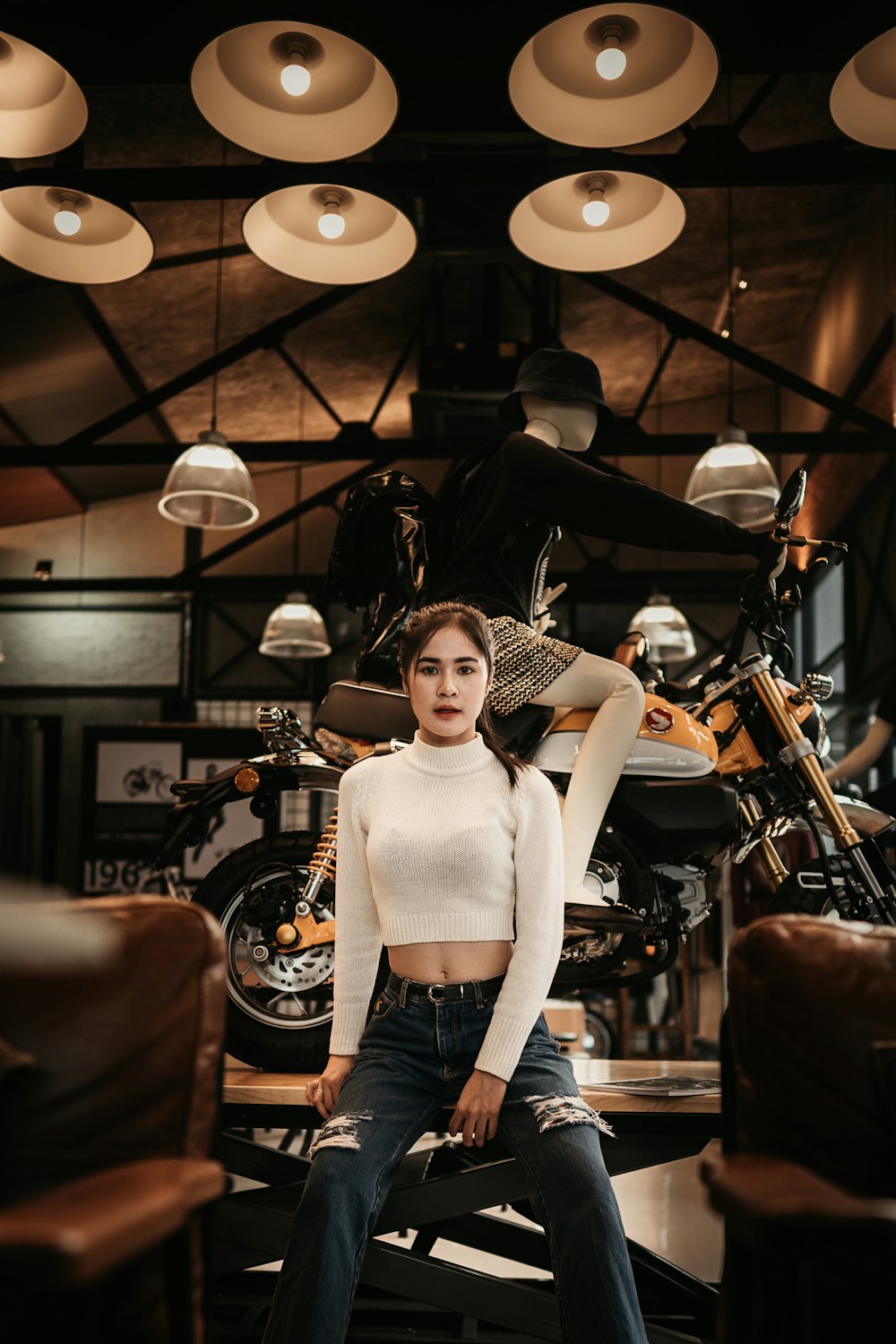woman wearing white turtleneck long-sleeved crop top sitting on brown wooden table